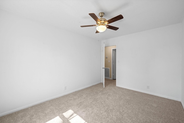 empty room featuring visible vents, light carpet, baseboards, and ceiling fan