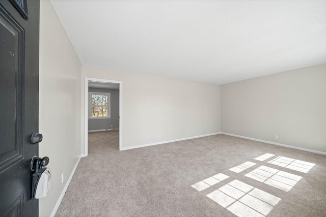 empty room featuring carpet and baseboards