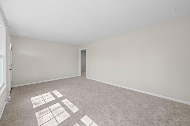 empty room featuring baseboards and carpet flooring