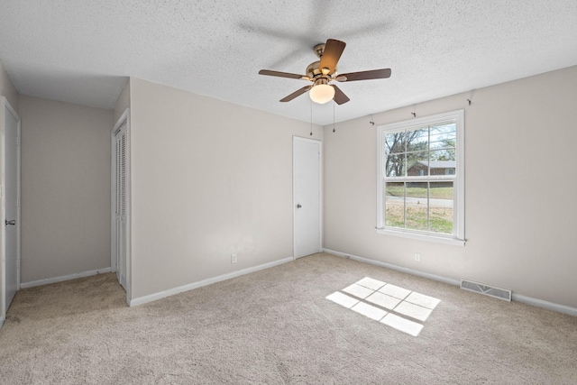 unfurnished bedroom featuring carpet, visible vents, a closet, and a textured ceiling