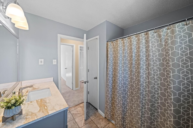 bathroom featuring tile patterned floors, curtained shower, a textured ceiling, and vanity