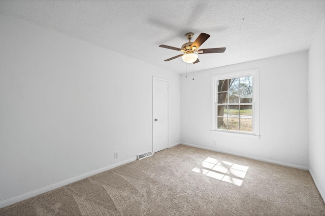 unfurnished room featuring visible vents, a textured ceiling, carpet, baseboards, and ceiling fan