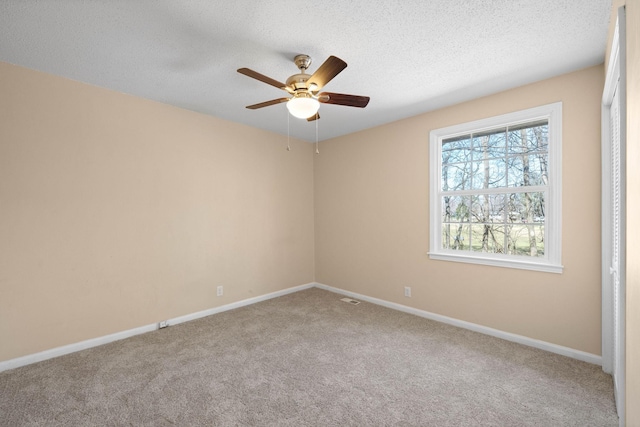 empty room with visible vents, baseboards, carpet flooring, a textured ceiling, and a ceiling fan