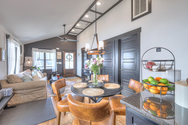 dining room featuring light wood-style flooring, visible vents, high vaulted ceiling, and ceiling fan