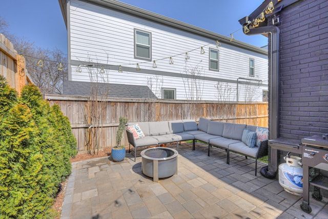 view of patio with an outdoor living space with a fire pit and a fenced backyard