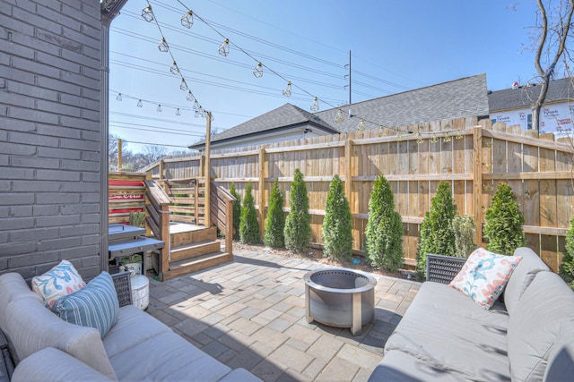 view of patio with an outdoor living space with a fire pit and fence