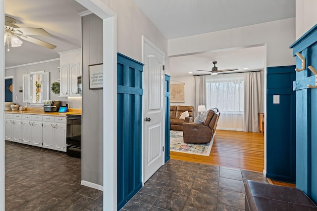 corridor featuring crown molding, baseboards, and dark wood-style flooring