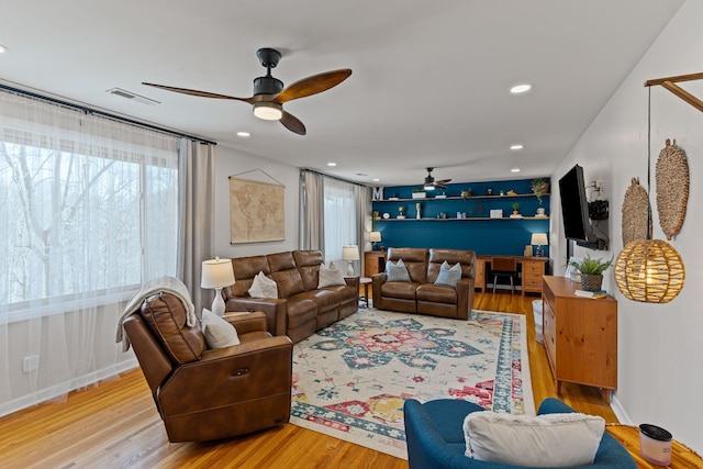 living area with wood finished floors, a ceiling fan, visible vents, baseboards, and recessed lighting