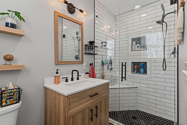 full bath with vanity, a shower stall, and toilet