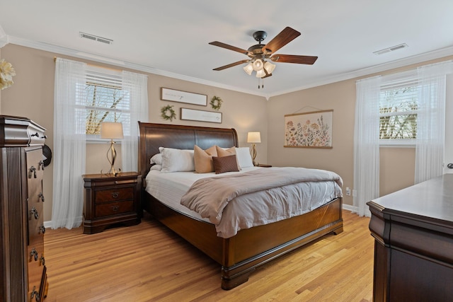 bedroom with visible vents, light wood-style floors, and ornamental molding