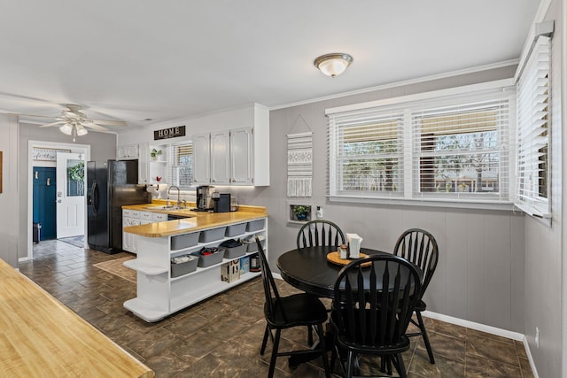 dining room with baseboards, crown molding, and a ceiling fan