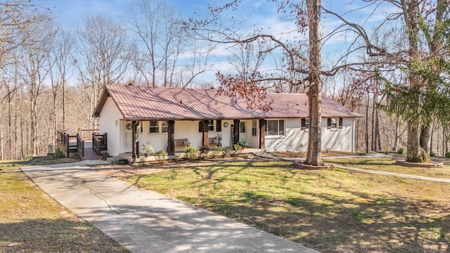 ranch-style house with a front yard, concrete driveway, covered porch, and stucco siding