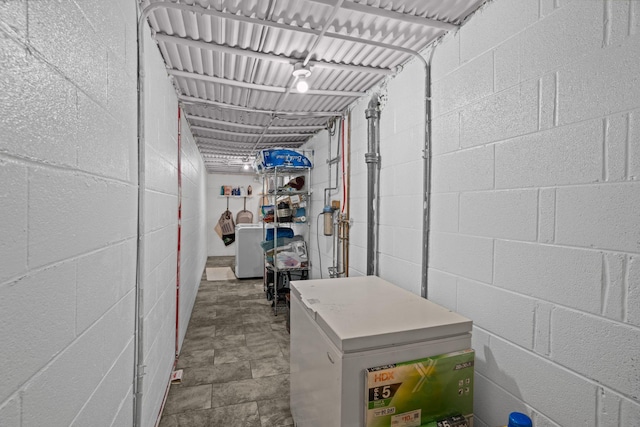 below grade area with refrigerator and concrete block wall