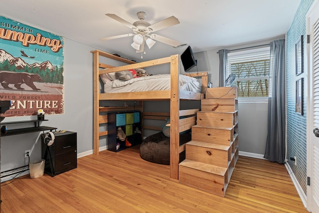 bedroom featuring a ceiling fan, wood finished floors, and baseboards