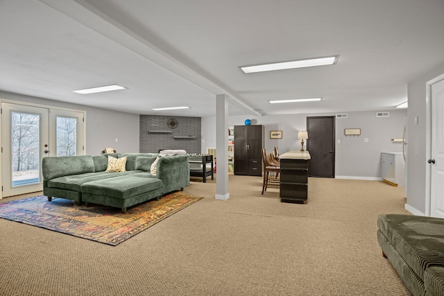 living area featuring a brick fireplace, visible vents, baseboards, and carpet floors