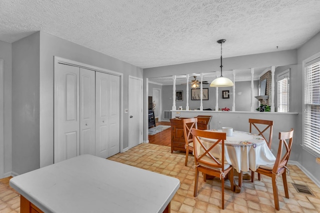 dining space featuring a ceiling fan, visible vents, and a wealth of natural light