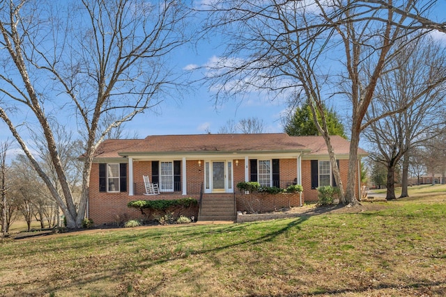 ranch-style home with brick siding, covered porch, and a front lawn