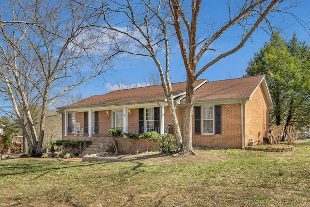 ranch-style home with brick siding, covered porch, and a front yard