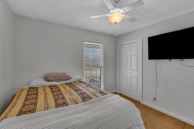 bedroom with ceiling fan, carpet, baseboards, and a textured ceiling