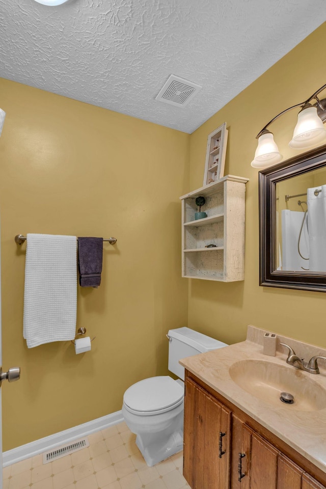 full bath featuring vanity, toilet, visible vents, and a textured ceiling