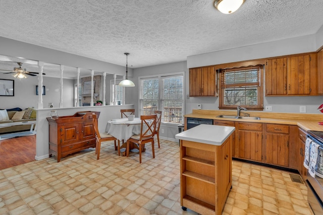 kitchen with light countertops, brown cabinetry, light floors, and open floor plan