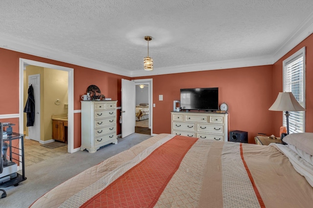 carpeted bedroom featuring ensuite bath, ornamental molding, baseboards, and a textured ceiling