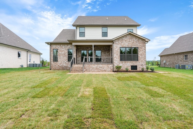 rear view of property featuring a porch, a yard, brick siding, and a shingled roof