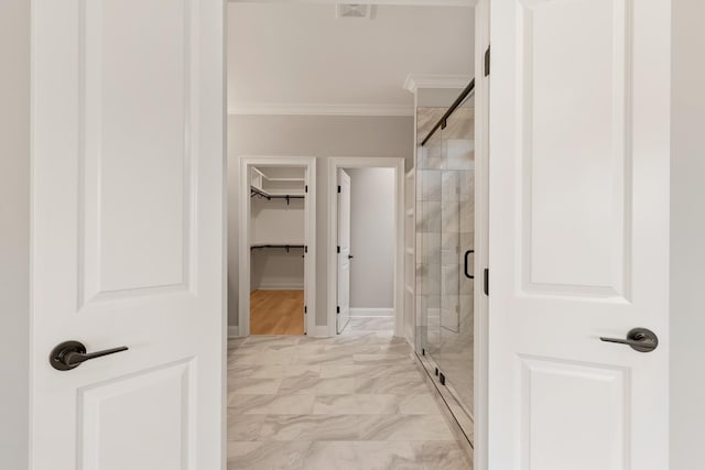 full bath with a stall shower, marble finish floor, ornamental molding, and a spacious closet