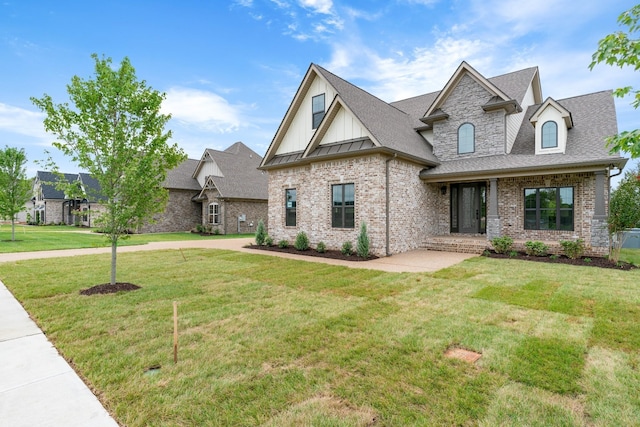 view of front of home with a front yard, a standing seam roof, a shingled roof, board and batten siding, and brick siding