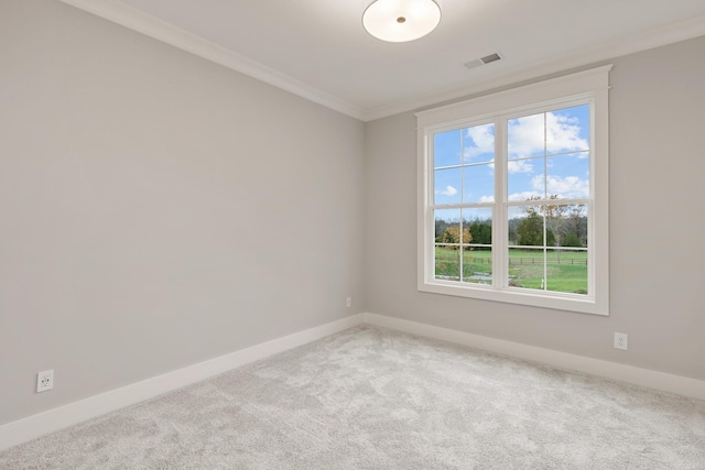 carpeted spare room featuring visible vents, crown molding, and baseboards