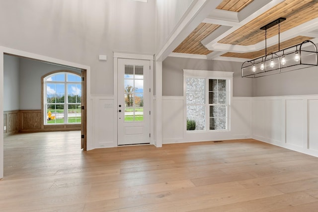 foyer with visible vents, light wood finished floors, an inviting chandelier, wainscoting, and beamed ceiling