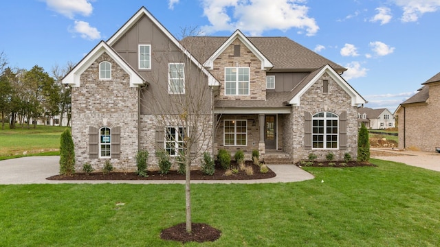 craftsman house with brick siding, roof with shingles, and a front yard