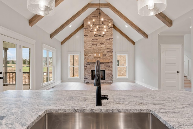 kitchen featuring open floor plan, beam ceiling, a notable chandelier, high vaulted ceiling, and a sink