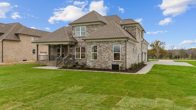 back of property featuring a garage, driveway, a yard, and roof with shingles