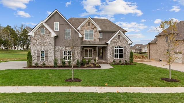 craftsman-style home featuring a front yard, brick siding, and roof with shingles