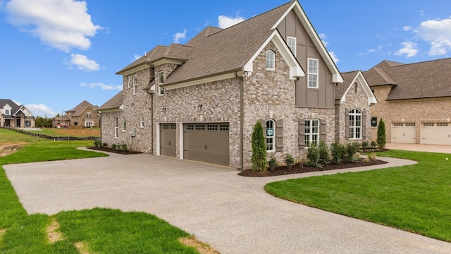 view of side of property with driveway, a yard, a shingled roof, a garage, and brick siding