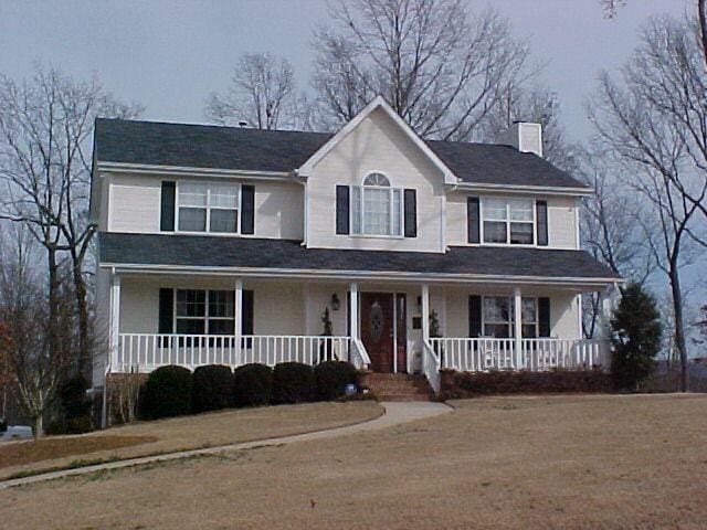 view of front of house featuring covered porch and a chimney