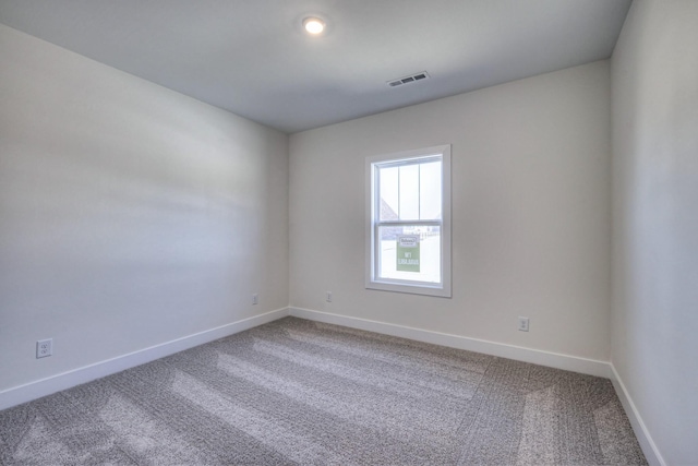 spare room with baseboards, visible vents, and carpet floors