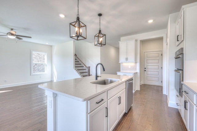 kitchen featuring a sink, backsplash, appliances with stainless steel finishes, and wood finished floors