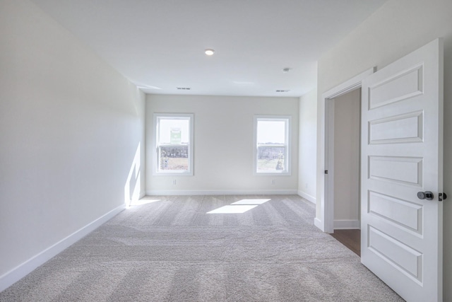 empty room with visible vents, carpet, and baseboards