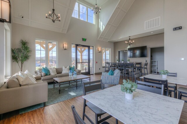 dining area with visible vents, an inviting chandelier, wood finished floors, and a healthy amount of sunlight