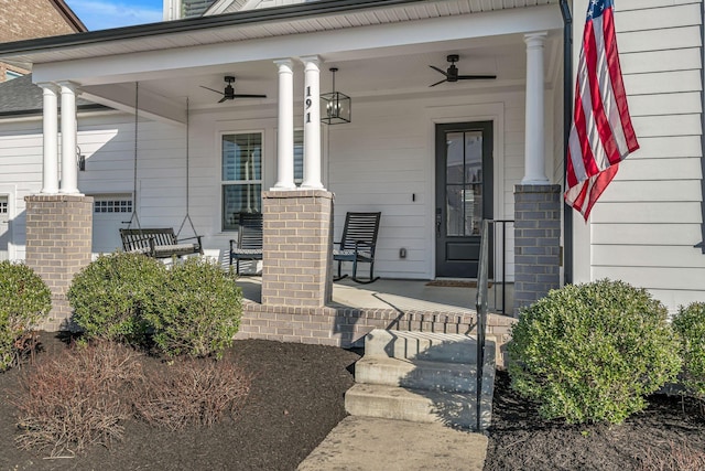 doorway to property with brick siding, a porch, and ceiling fan