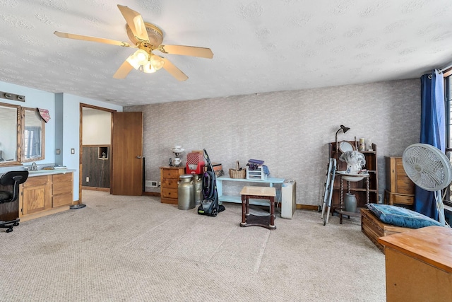 home office with baseboards, light colored carpet, a ceiling fan, and a textured ceiling