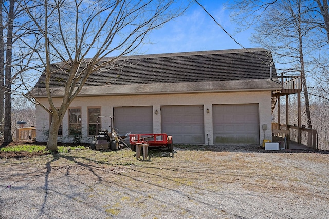 exterior space featuring a shingled roof, a garage, and stucco siding