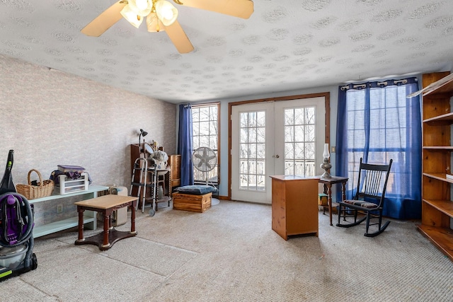 office area with a ceiling fan, carpet floors, wallpapered walls, french doors, and a textured ceiling