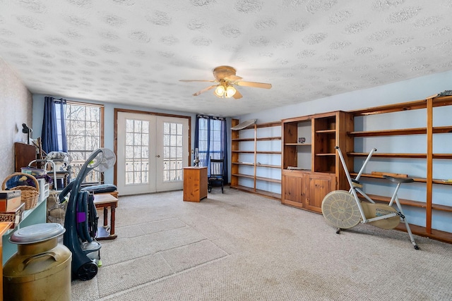 misc room featuring a textured ceiling, light carpet, french doors, and ceiling fan