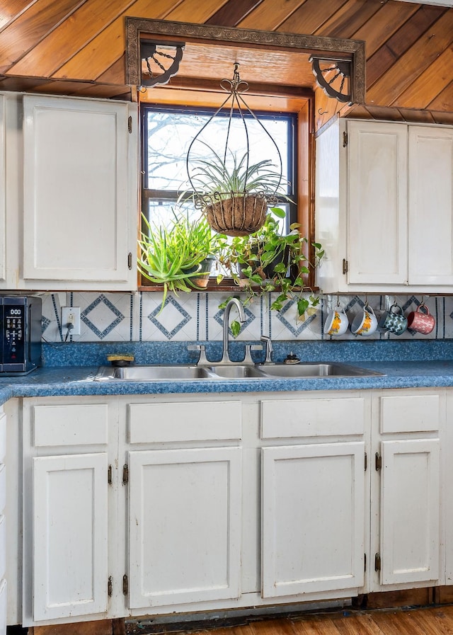 kitchen featuring white cabinets, a wealth of natural light, and a sink