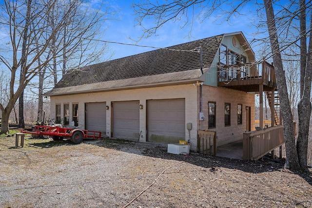 view of home's exterior with a gambrel roof, a balcony, and a shingled roof