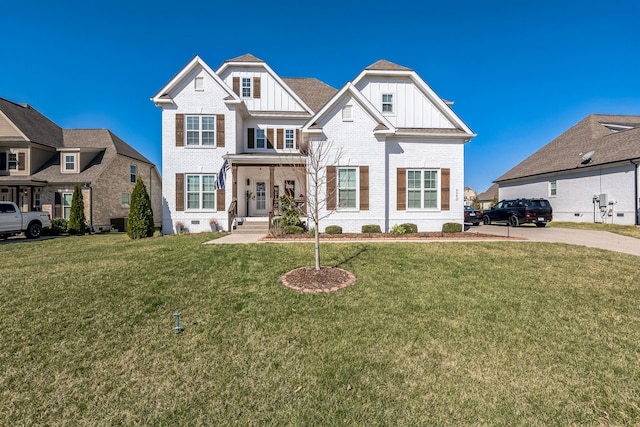 view of front of property with a front lawn, brick siding, board and batten siding, and crawl space