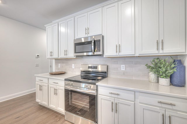 kitchen featuring tasteful backsplash, light wood-style flooring, appliances with stainless steel finishes, and light countertops